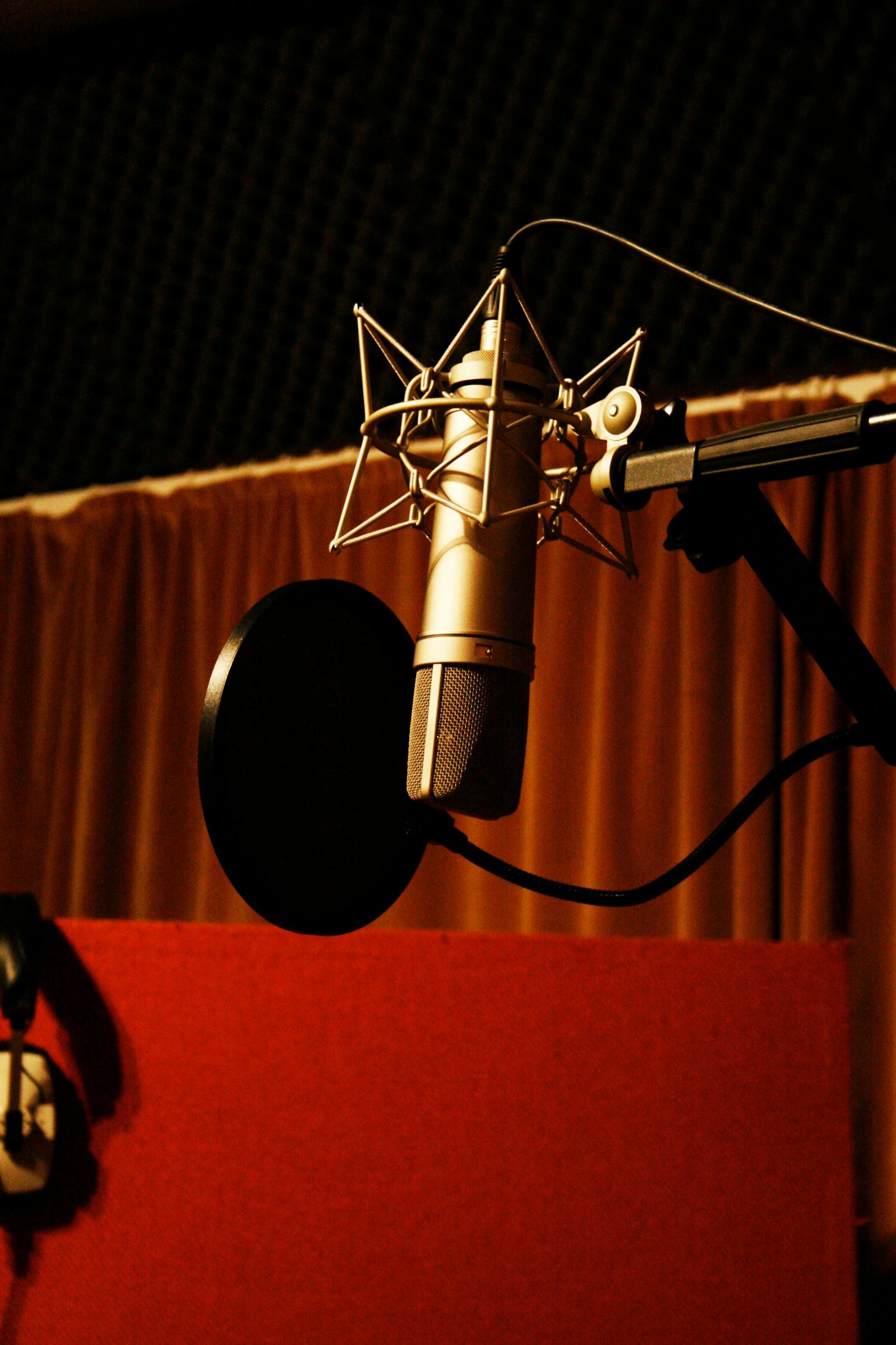 A studio microphone in a warm pool of light